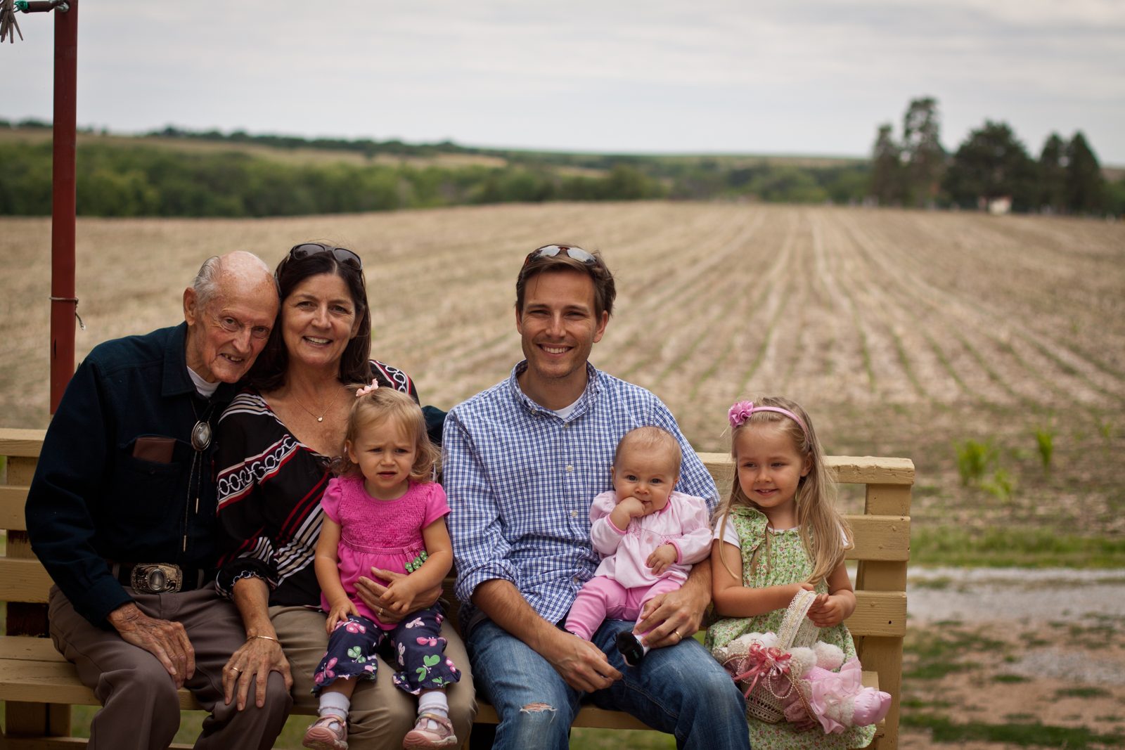 Duane Wilkinson in his bolo tie, seated with four generations of family on the Nebraska farm